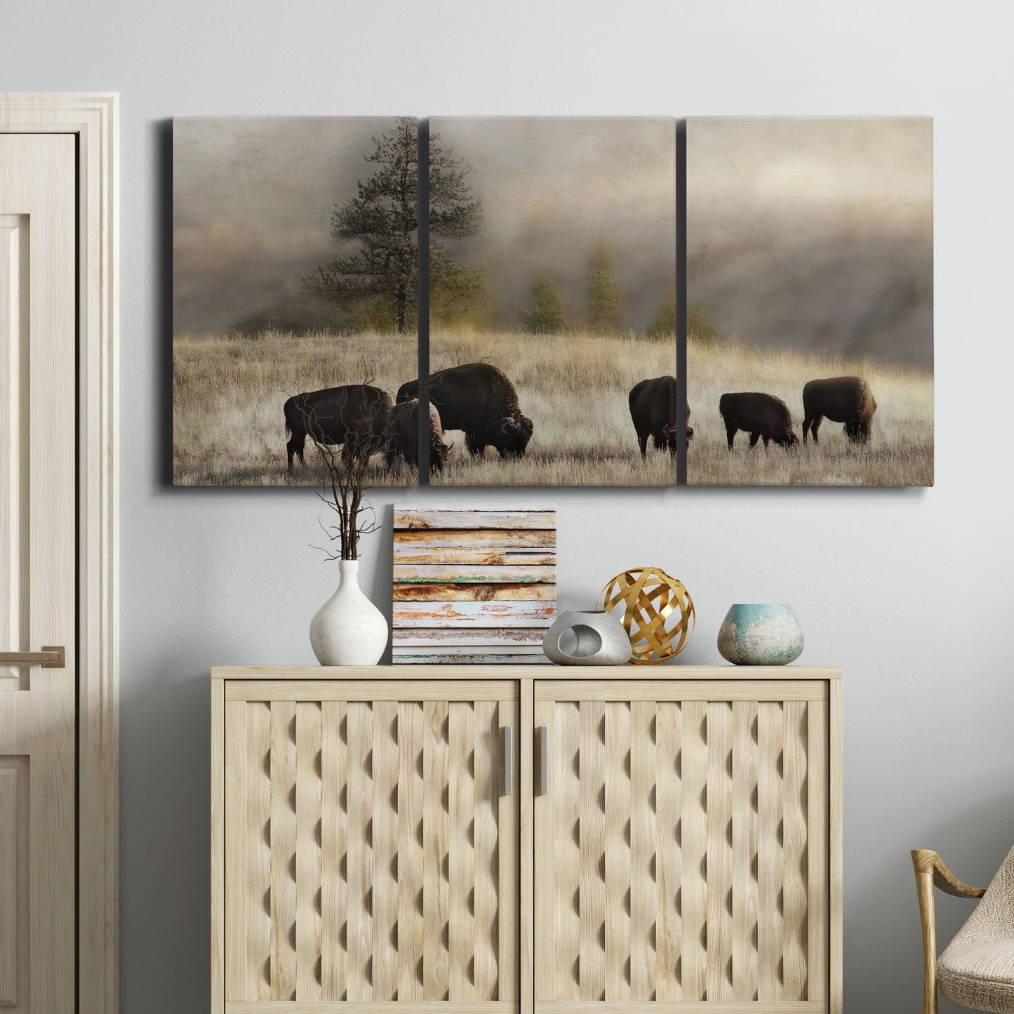 Three-panel canvas wall art featuring cattle grazing along ridge line, displayed above a cabinet in an entryway.