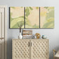 Three-panel canvas wall art featuring minimal verdant floral abstraction, displayed above a cabinet in an entryway.