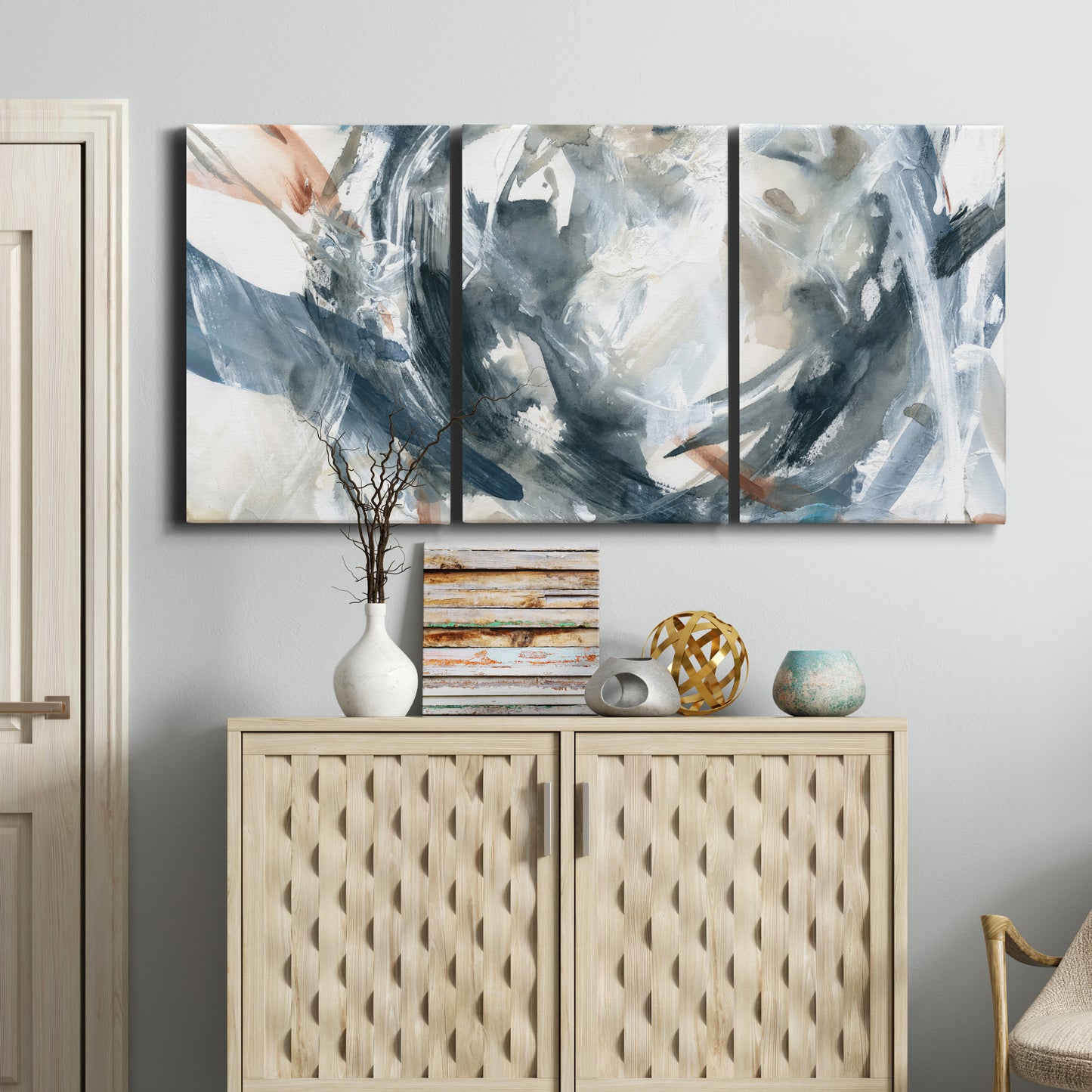 Three-panel canvas wall art featuring repeating abstract geometric array, displayed above a cabinet in an entryway.