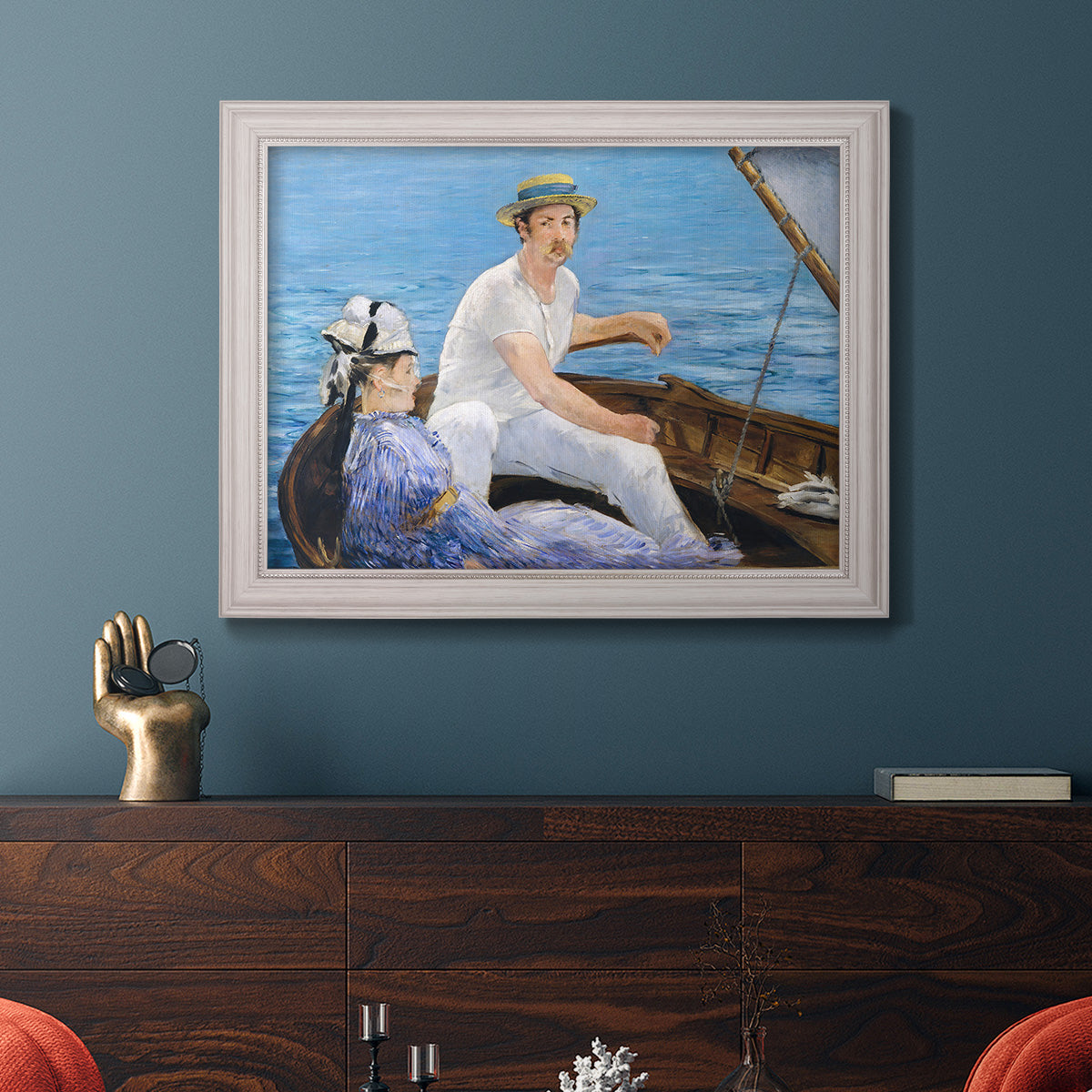 Impressionist leisure boating scene by Édouard Manet in an ornate weathered white frame displayed in a dark-toned interior setting.