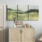 Three-panel canvas wall art featuring rolling hillside countryside landscape, displayed above a cabinet in an entryway.
