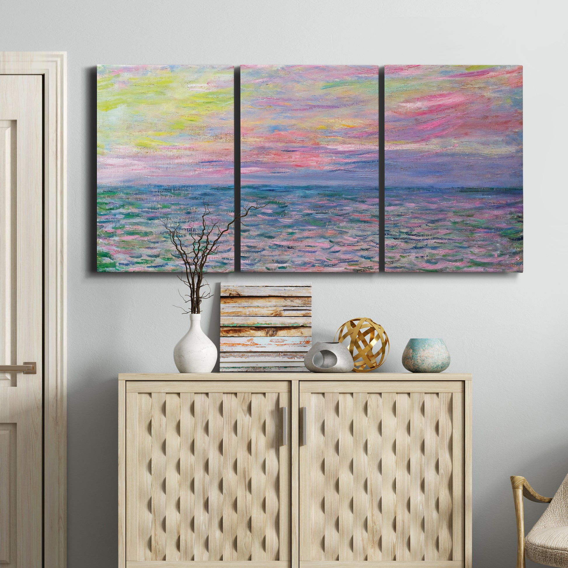 Three-panel canvas wall art featuring sunset reflections across calm sea, displayed above a cabinet in an entryway.