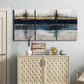 Three-panel canvas wall art featuring abstract blue urban composition, displayed above a cabinet in an entryway.