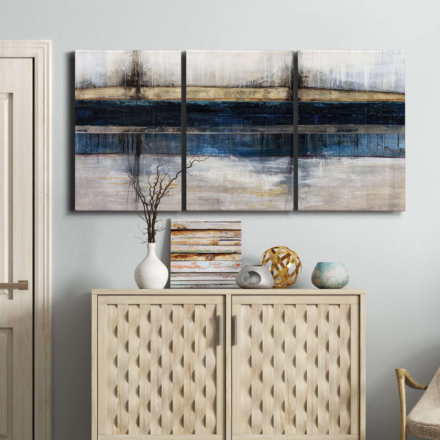 Three-panel canvas wall art featuring abstract blue urban composition, displayed above a cabinet in an entryway.