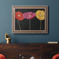 Contemporary poppy flower artwork in an ornate traditional silver frame displayed in a dark-toned interior setting.