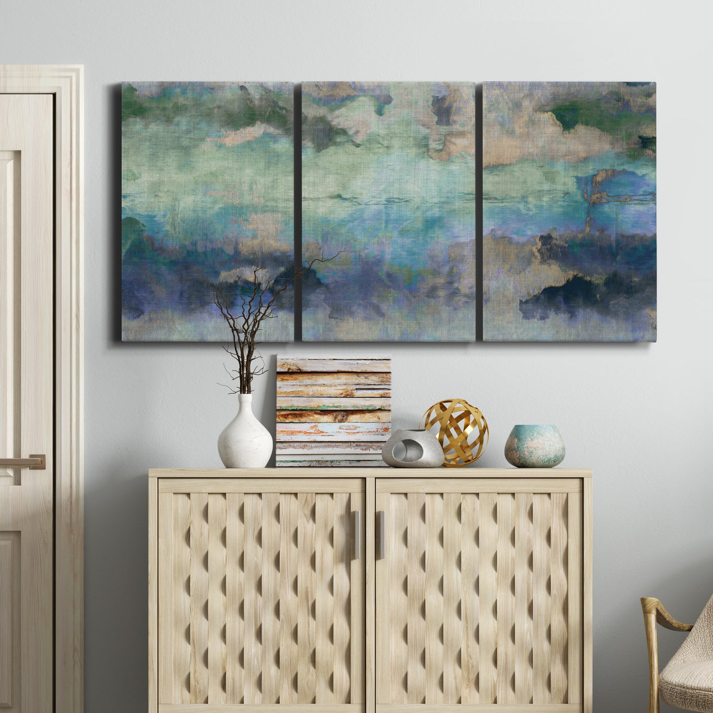 Three-panel canvas wall art featuring cool dreamy abstraction, displayed above a cabinet in an entryway.