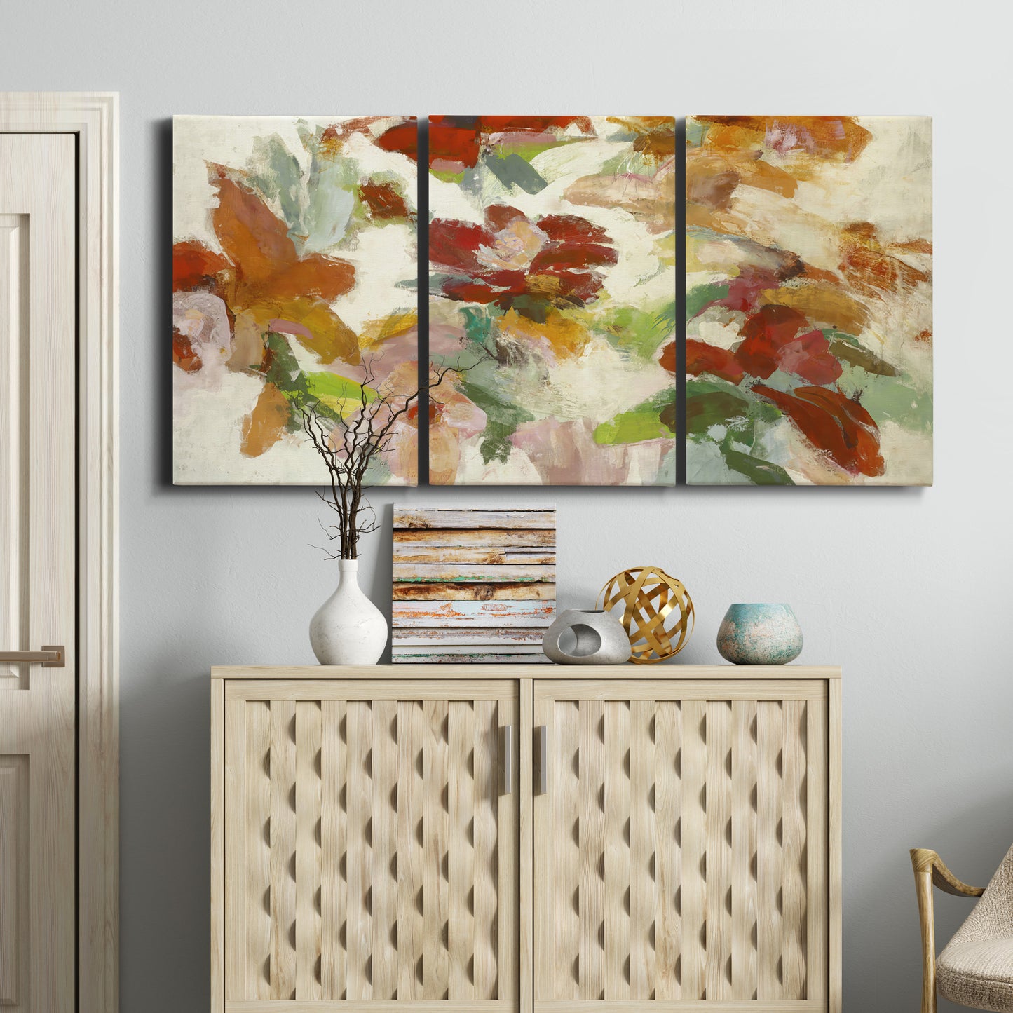 Three-panel canvas wall art featuring layered floral botanical impressions, displayed above a cabinet in an entryway.
