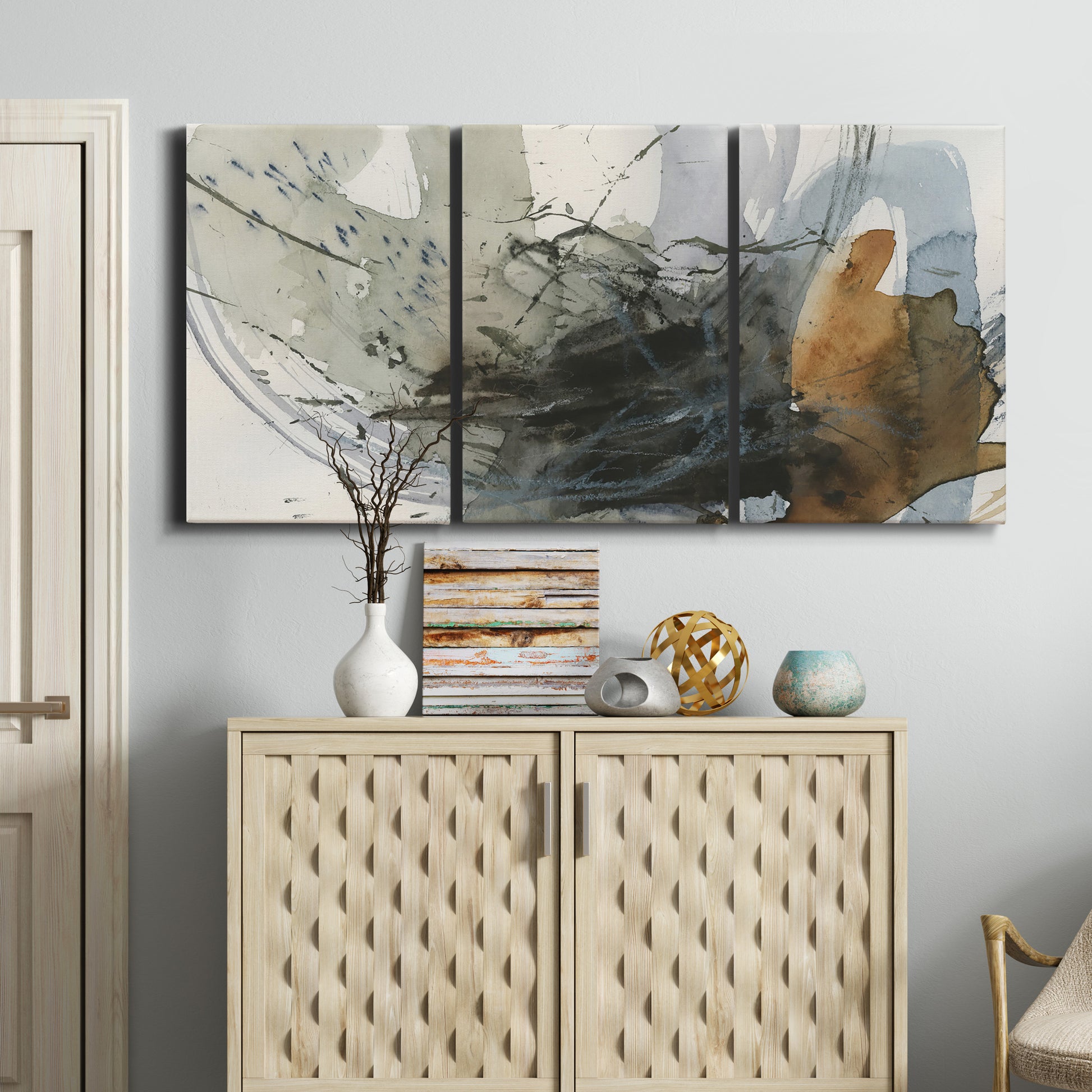 Three-panel canvas wall art featuring dynamic circular abstract motion, displayed above a cabinet in an entryway.