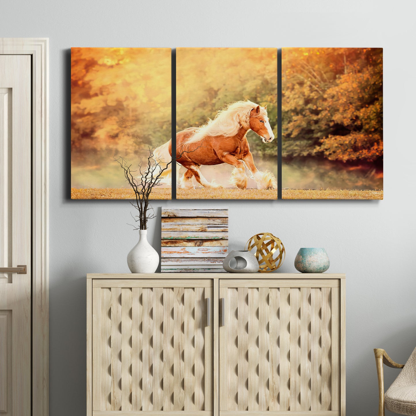 Three-panel canvas wall art featuring running horses captured in motion, displayed above a cabinet in an entryway.