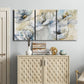 Three-panel canvas wall art featuring delicate watercolor floral blooms, displayed above a cabinet in an entryway.