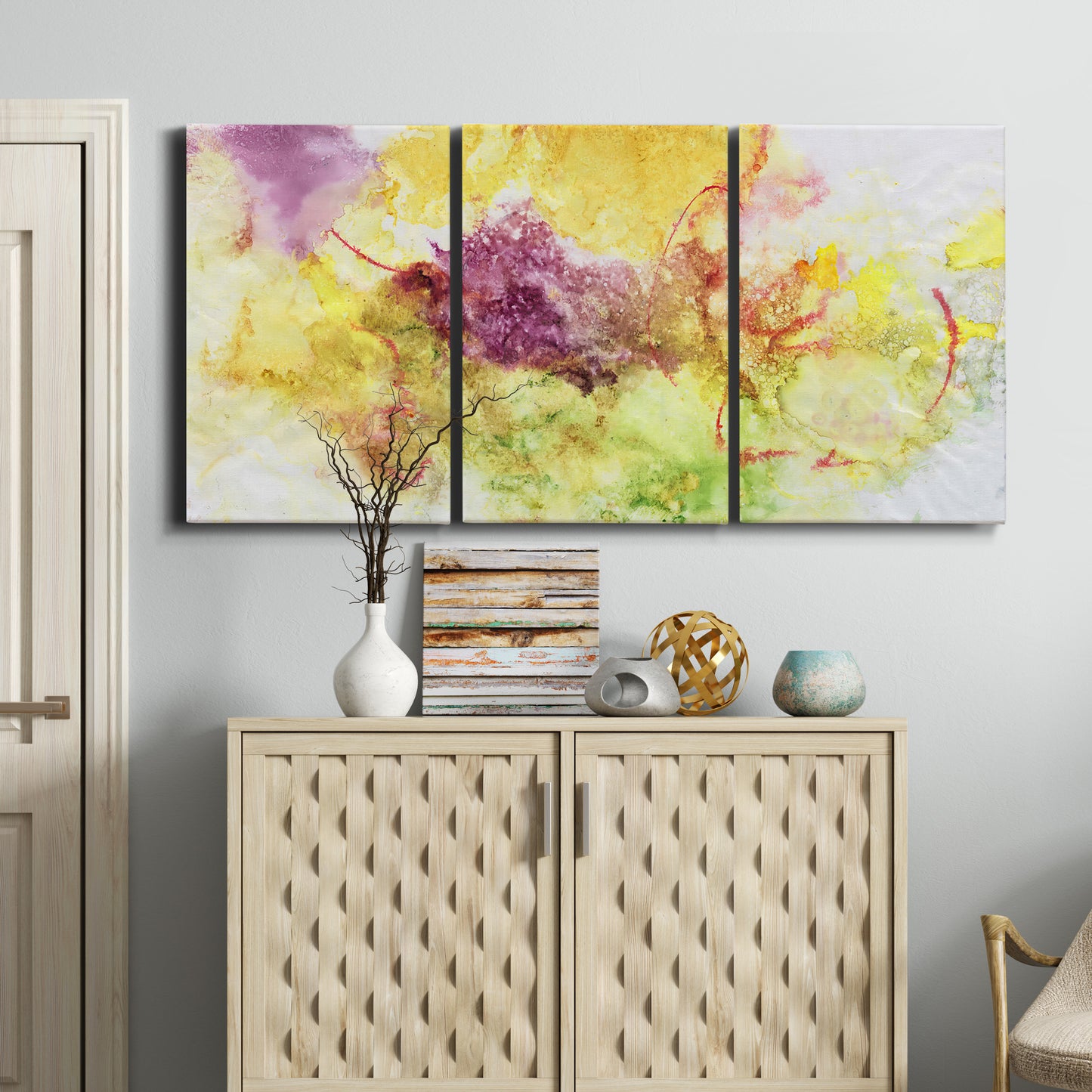 Three-panel canvas wall art featuring abstract floral rhythm composition, displayed above a cabinet in an entryway.