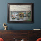 Impressionist river bridge scene on an overcast day by Claude Monet in an ornate black frame with gilded inner detail displayed in a dark-toned interior setting.