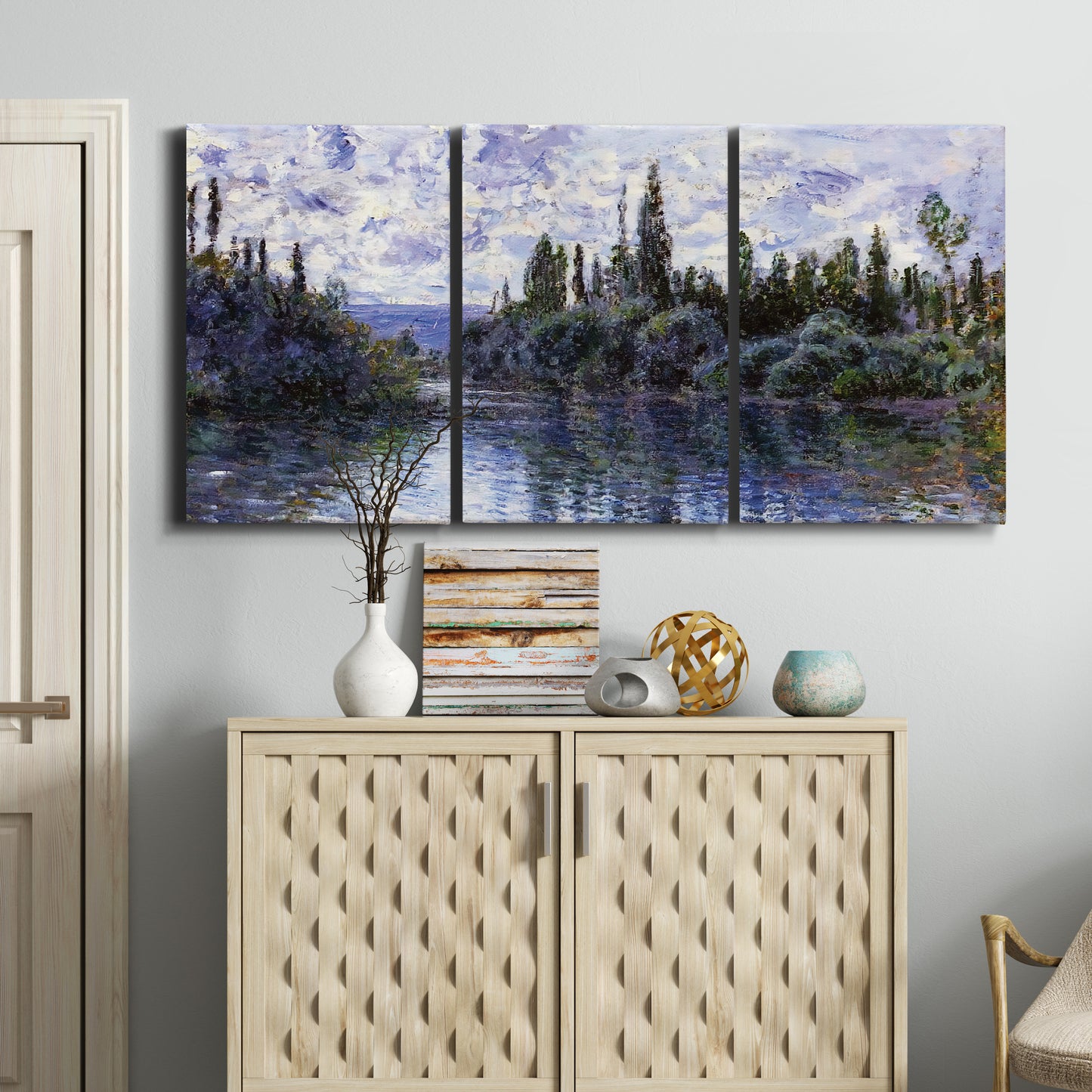 Three-panel canvas wall art featuring quiet river bend near village, displayed above a cabinet in an entryway.