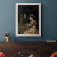 Classical interior scene of a woman weaving flowers by Godfried Schalcken in an ornate weathered white frame displayed in a dark-toned interior setting.