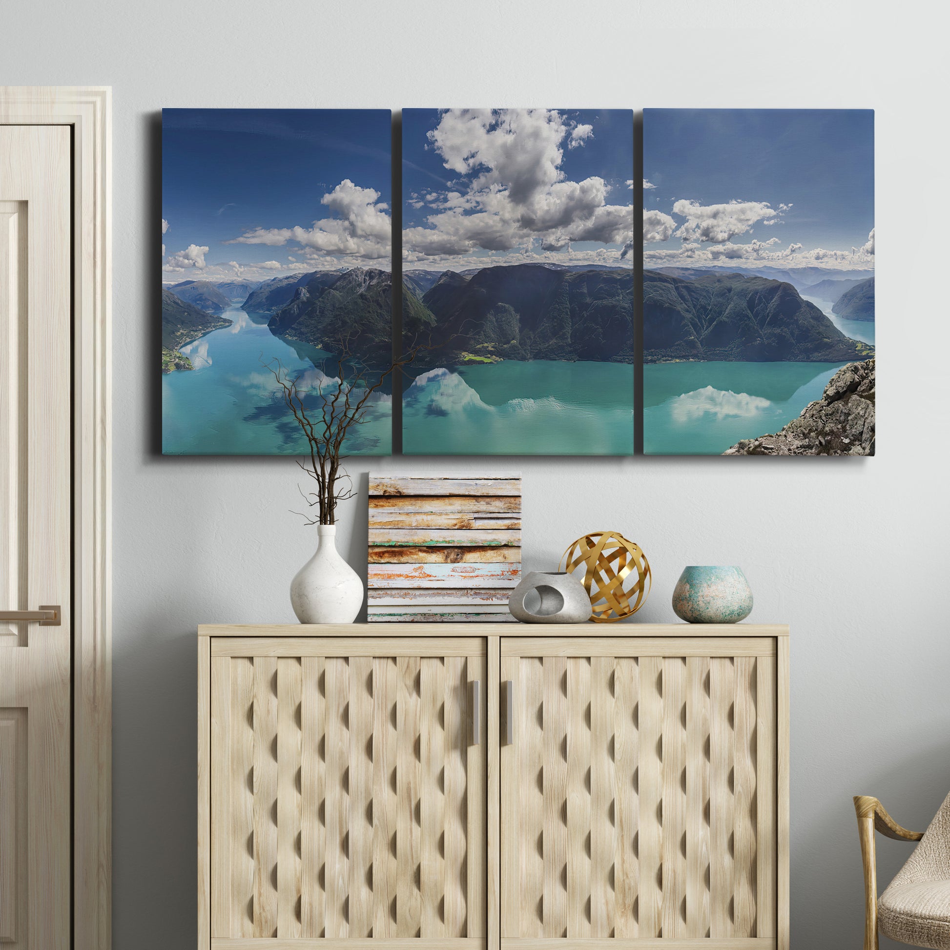 Three-panel canvas wall art featuring tropical water reflections with foliage, displayed above a cabinet in an entryway.