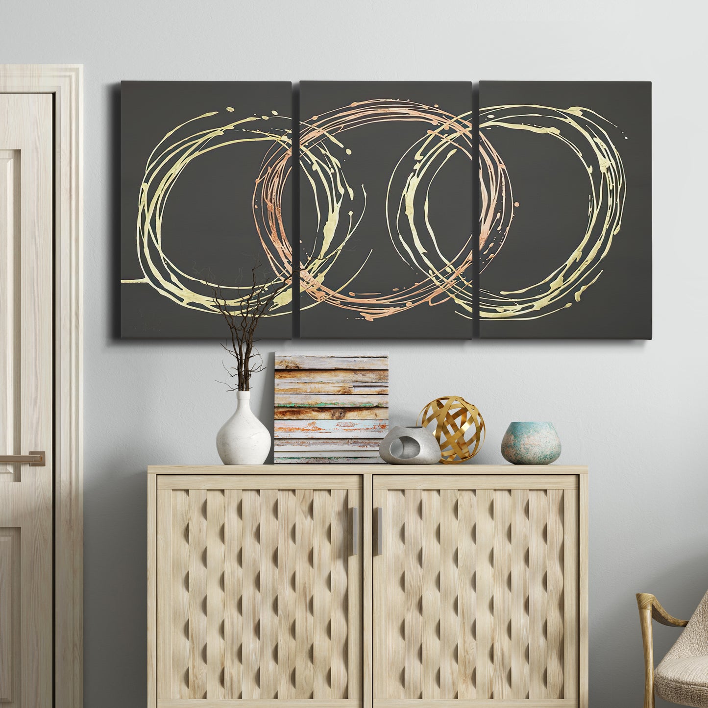 Three-panel canvas wall art featuring geometric abstract wave tangents, displayed above a cabinet in an entryway.