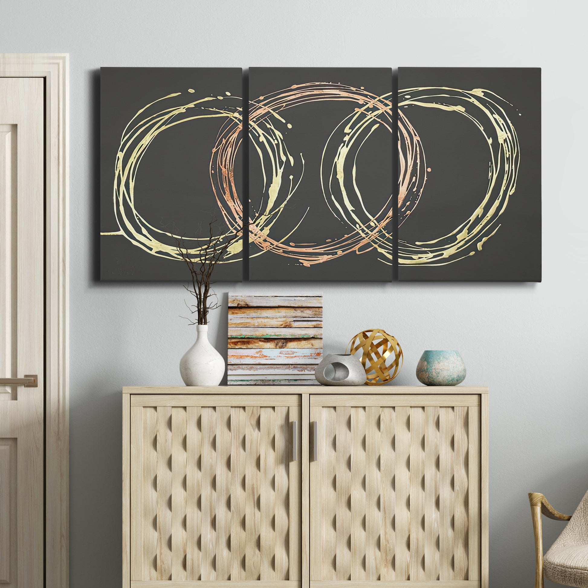 Three-panel canvas wall art featuring geometric abstract wave tangents, displayed above a cabinet in an entryway.