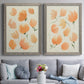 Set of two gray barnwood framed canvas prints depicting paired airy watercolor floral paintings with soft petals, thin black stems, and warm cream backgrounds above a sofa in a contemporary living room.