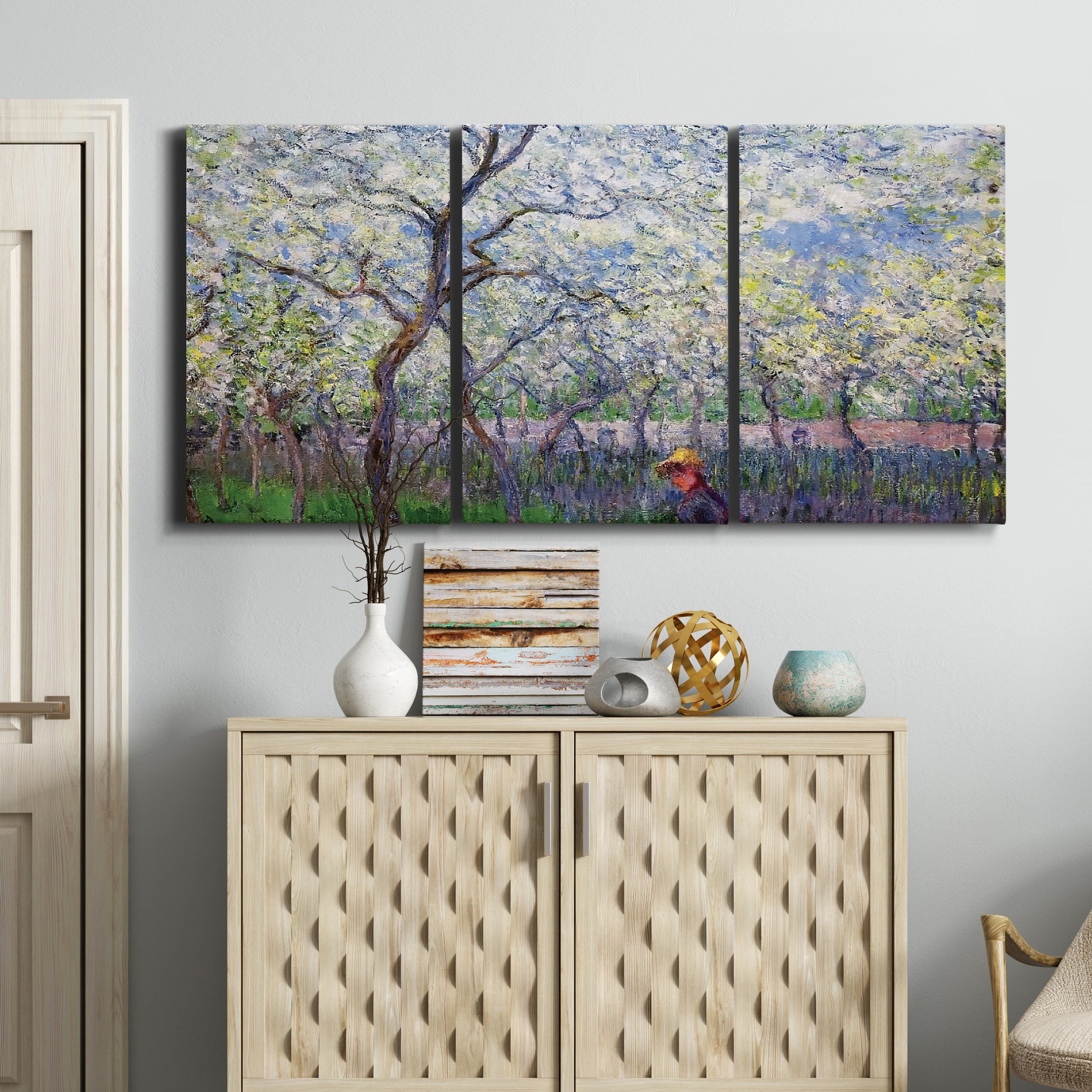 Three-panel canvas wall art featuring fresh spring countryside landscape, displayed above a cabinet in an entryway.