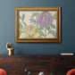 Contemporary peony flower illustration in an ornate traditional gold frame displayed in a dark-toned interior setting.