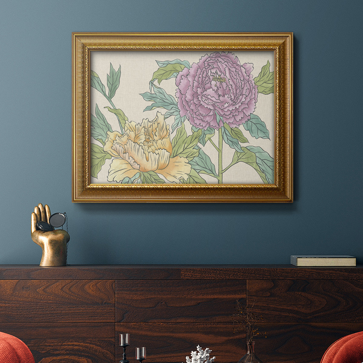 Contemporary peony flower illustration in an ornate traditional gold frame displayed in a dark-toned interior setting.