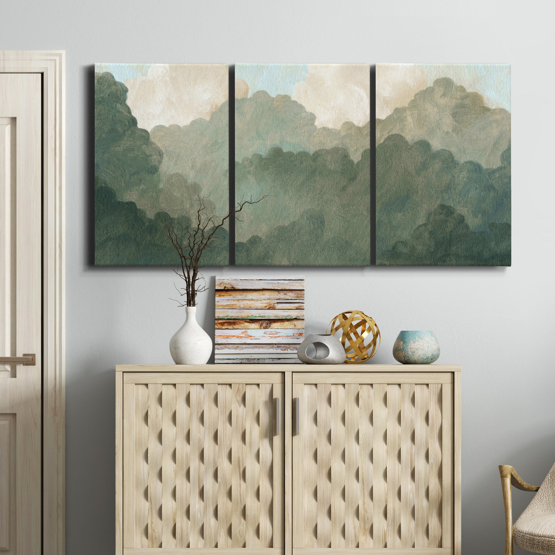 Three-panel canvas wall art featuring autumn storm over rolling landscape, displayed above a cabinet in an entryway.