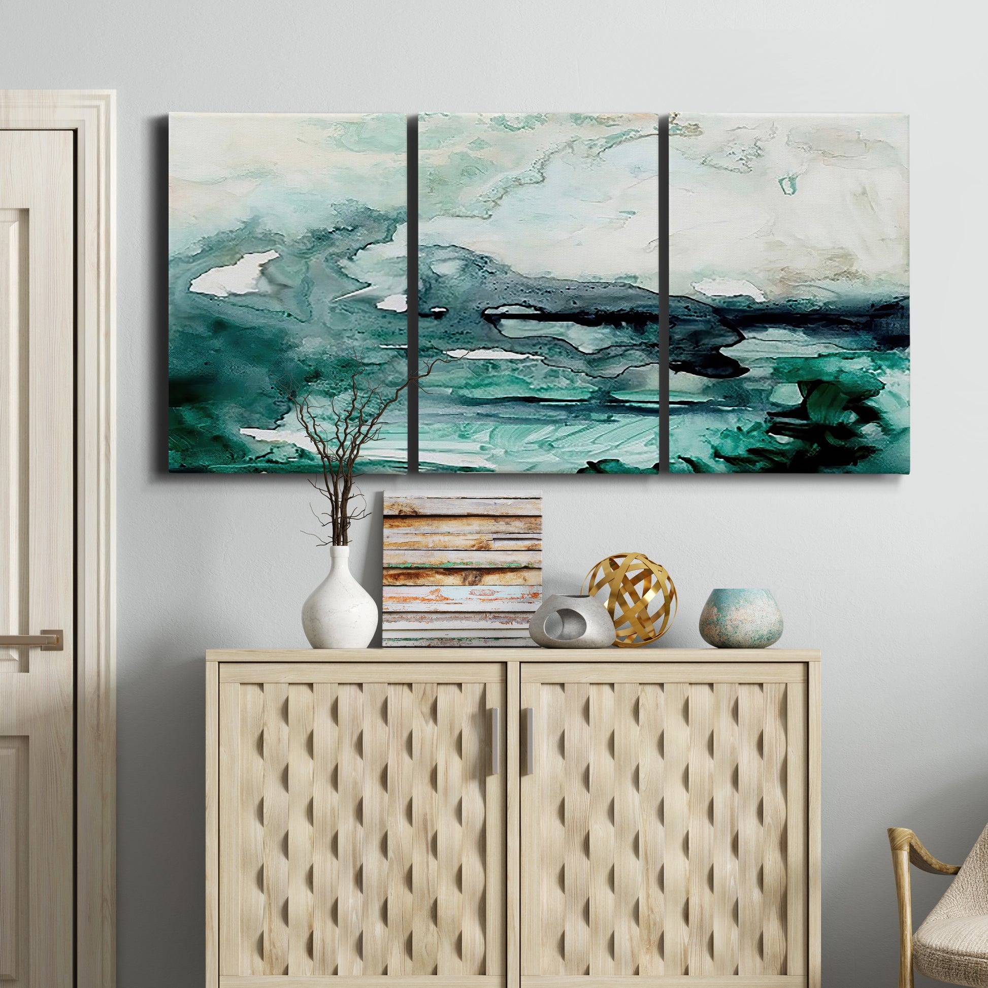 Three-panel canvas wall art featuring coastal abstract sea foam movement, displayed above a cabinet in an entryway.