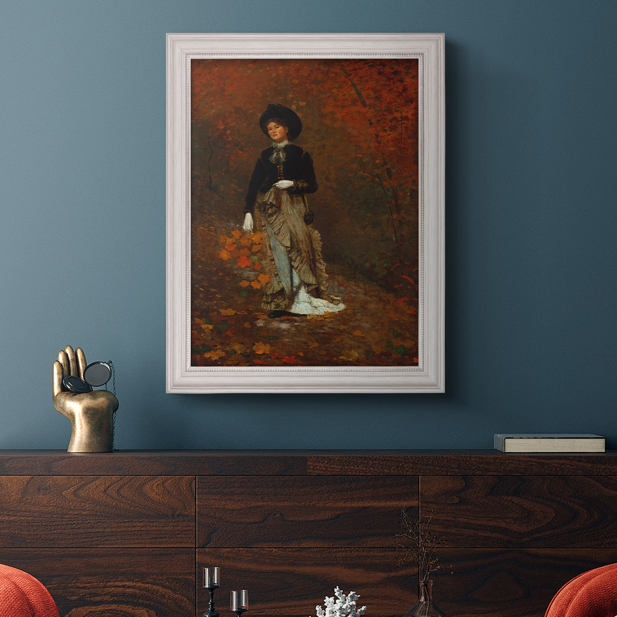 Realist autumn portrait scene by Winslow Homer in an ornate weathered white frame displayed in a dark-toned interior setting.