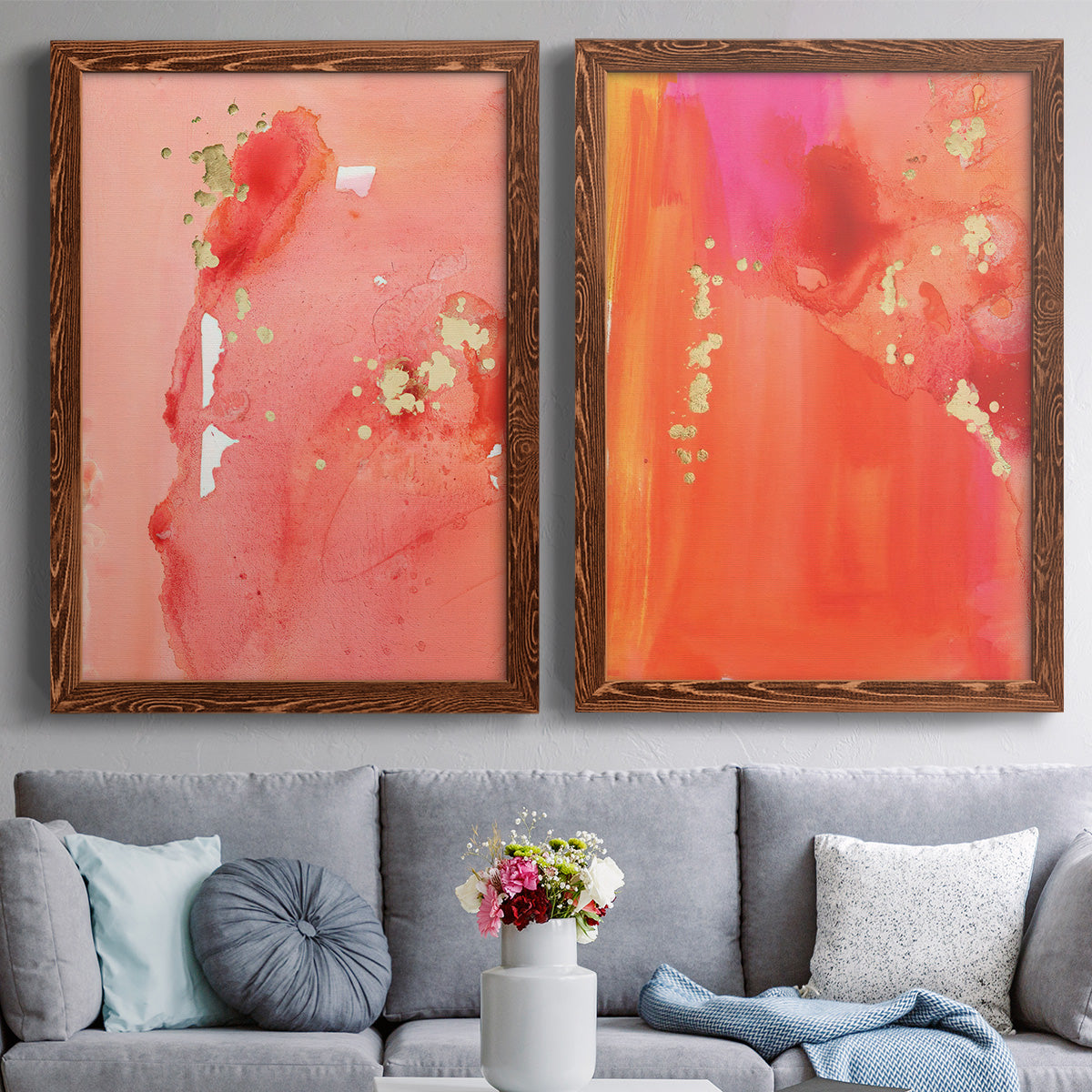 Set of two maple barnwood framed canvas prints depicting paired glamorous fluid abstracts with translucent warm washes, drips, and scattered metallic accents above a sofa in a contemporary living room.