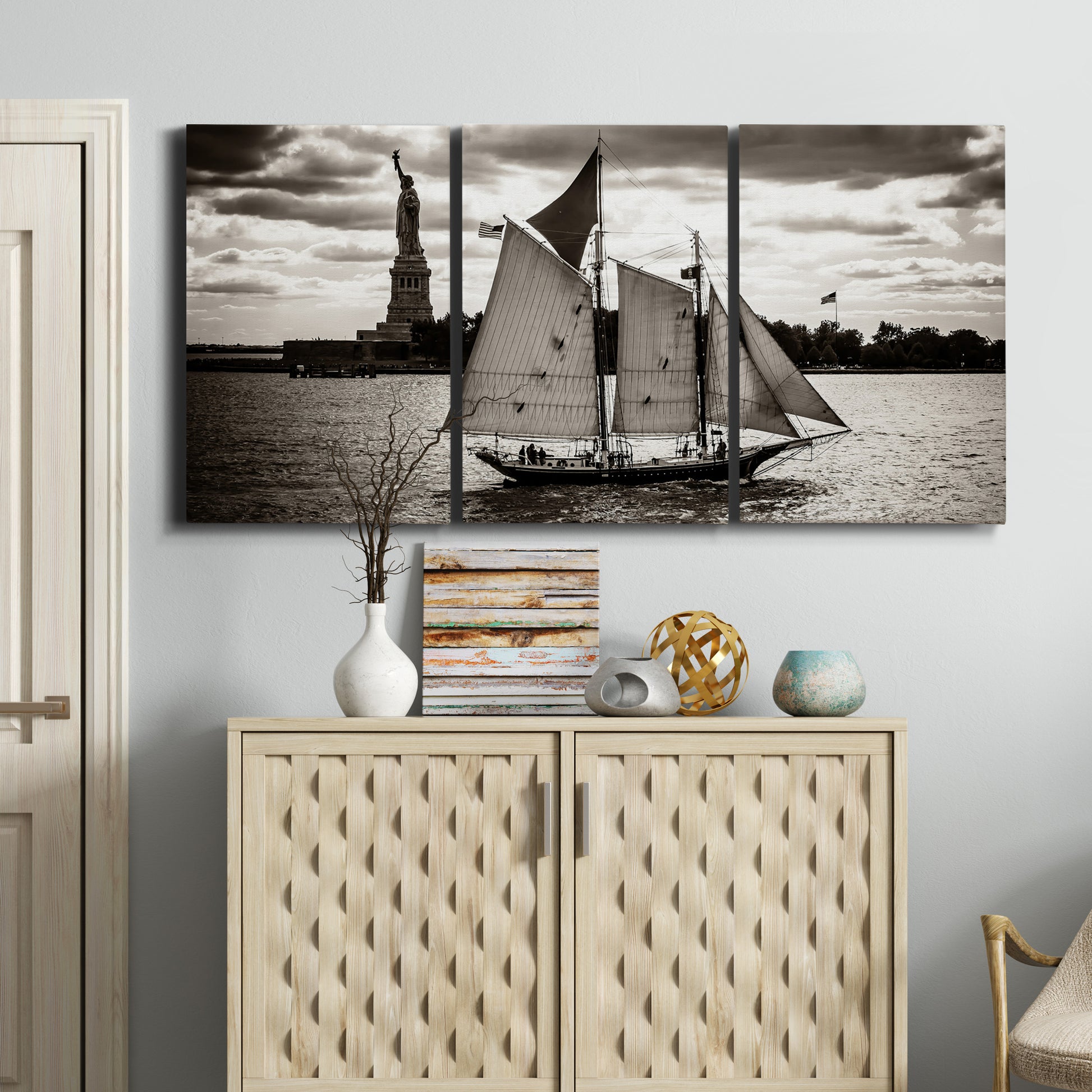 Three-panel canvas wall art featuring historic sailing ships photograph, displayed above a cabinet in an entryway.