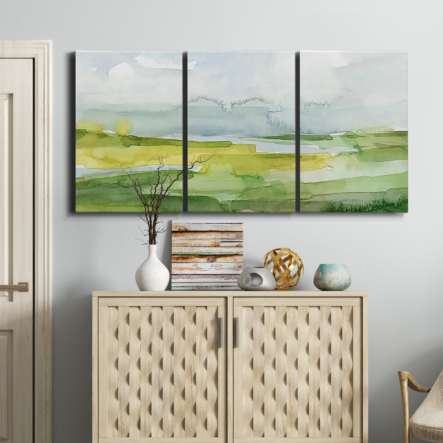 Three-panel canvas wall art featuring lowland wetlands with reflective water, displayed above a cabinet in an entryway.