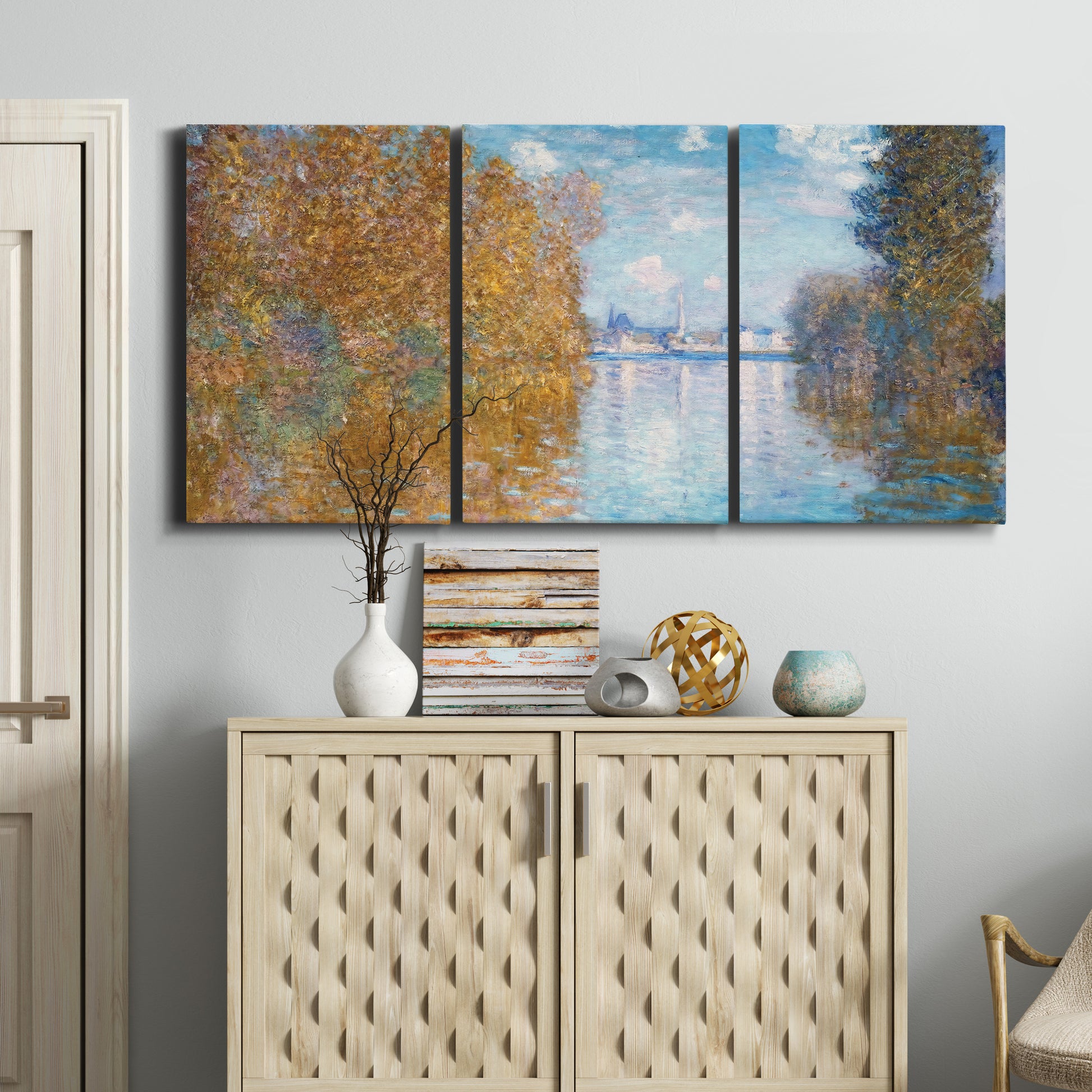 Three-panel canvas wall art featuring autumn landscape with glowing foliage, displayed above a cabinet in an entryway.
