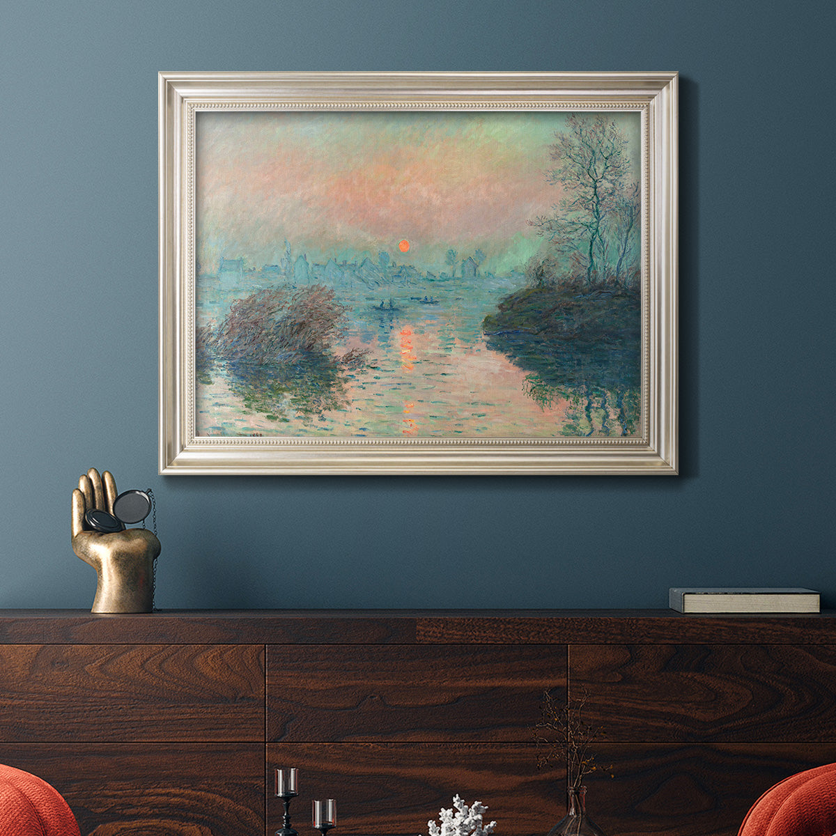 Impressionist winter river sunset scene by Claude Monet in an ornate champagne frame displayed in a dark-toned interior setting.