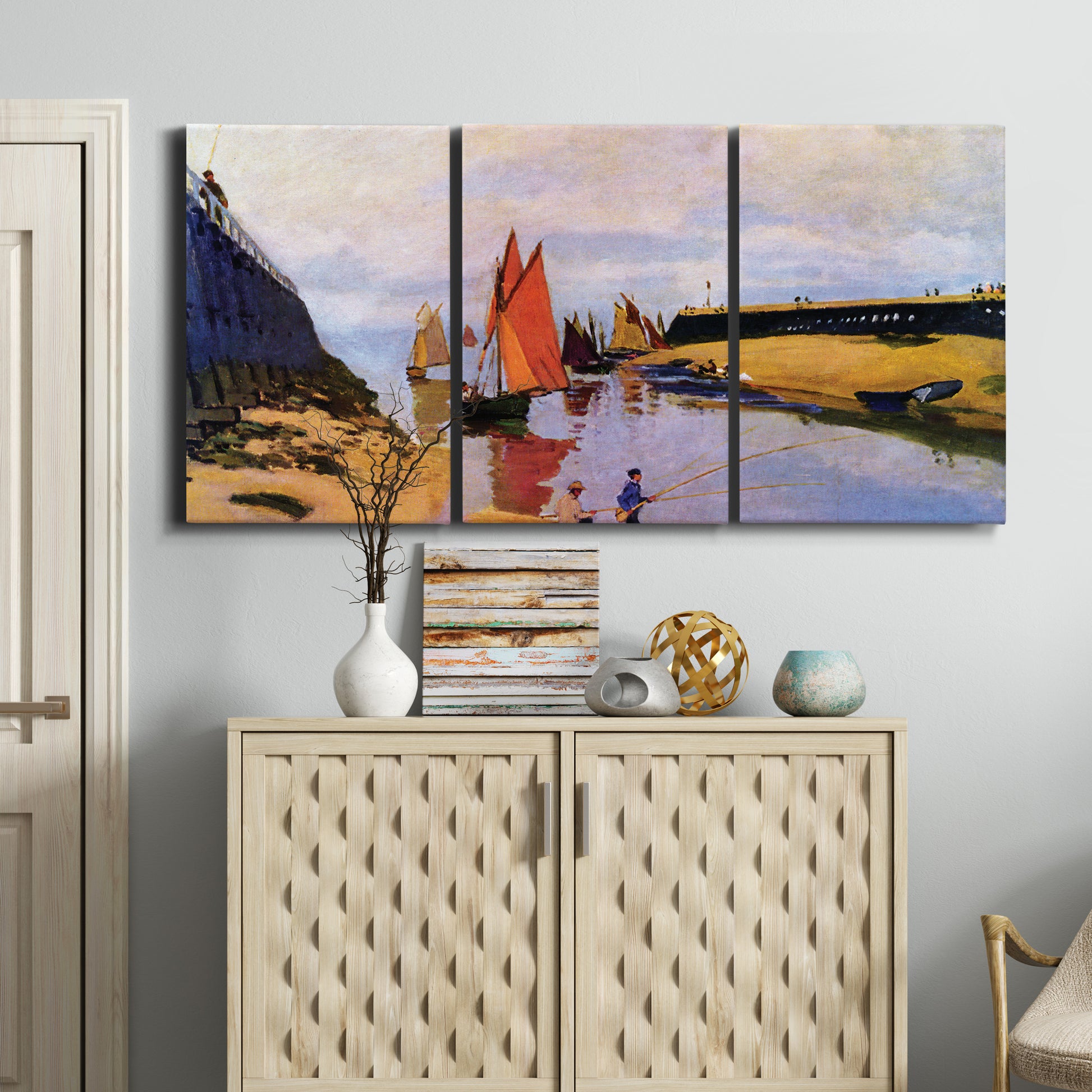 Three-panel canvas wall art featuring stone breakwater at low tide, displayed above a cabinet in an entryway.