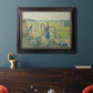 Impressionist rural hay harvest landscape by Camille Pissarro in an ornate black frame with gilded inner detail displayed in a dark-toned interior setting.