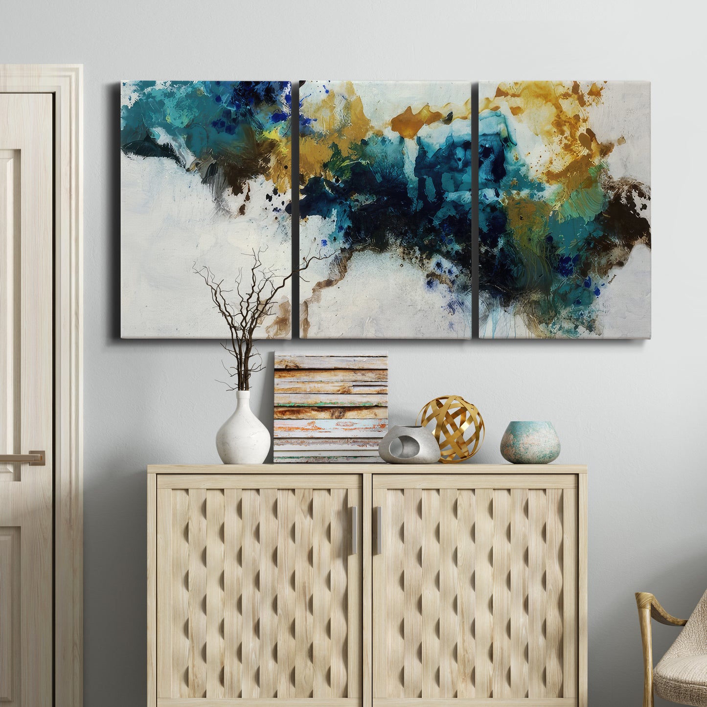 Three-panel canvas wall art featuring teal abstract paint splatter, displayed above a cabinet in an entryway.
