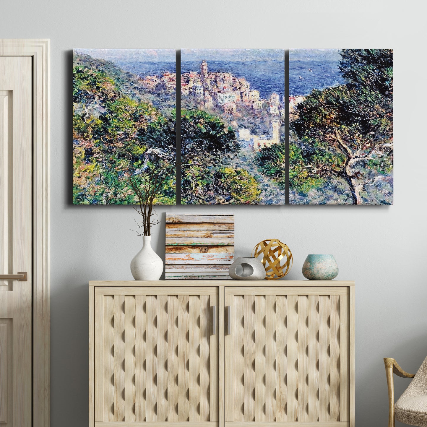 Three-panel canvas wall art featuring coastal hillside overlooking monaco, displayed above a cabinet in an entryway.