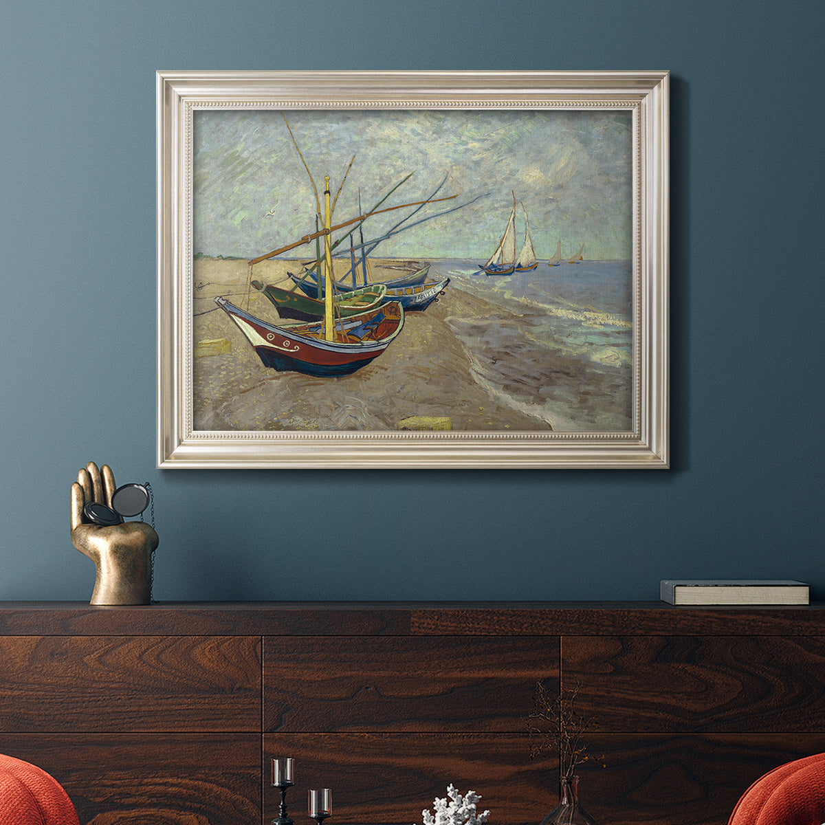 Impressionist coastal fishing boats scene by Vincent van Gogh in an ornate champagne frame displayed in a dark-toned interior setting.