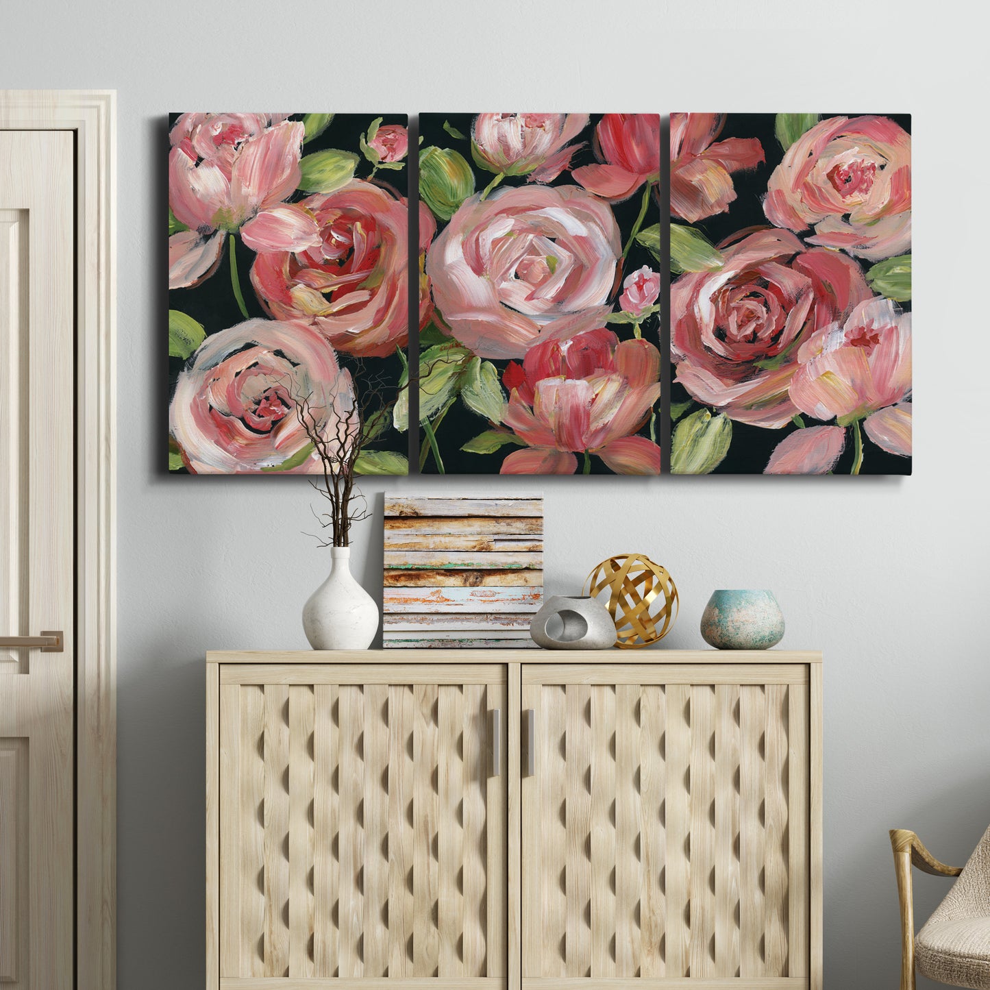 Three-panel canvas wall art featuring bold red floral abstraction, displayed above a cabinet in an entryway.
