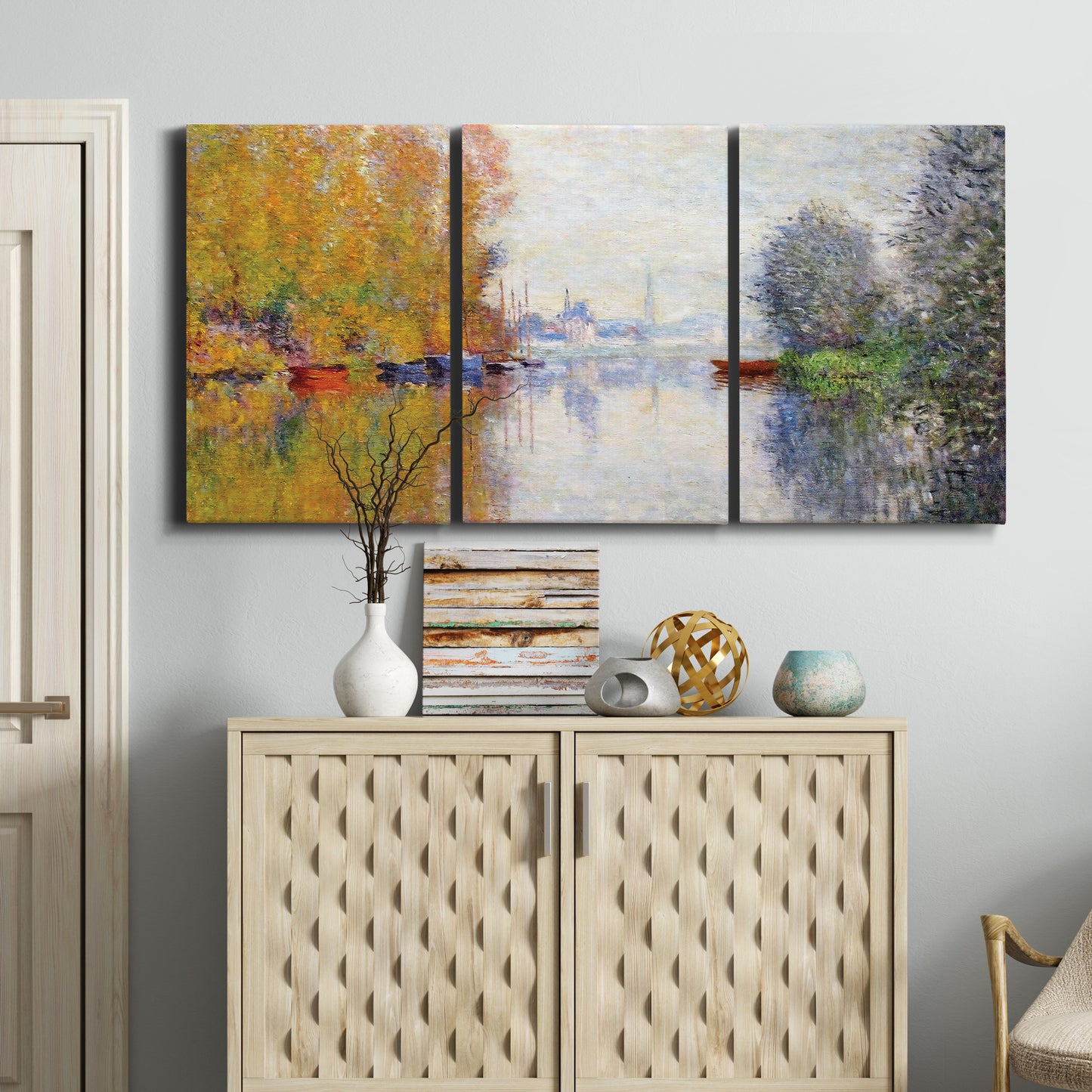 Three-panel canvas wall art featuring golden autumn light over riverside, displayed above a cabinet in an entryway.
