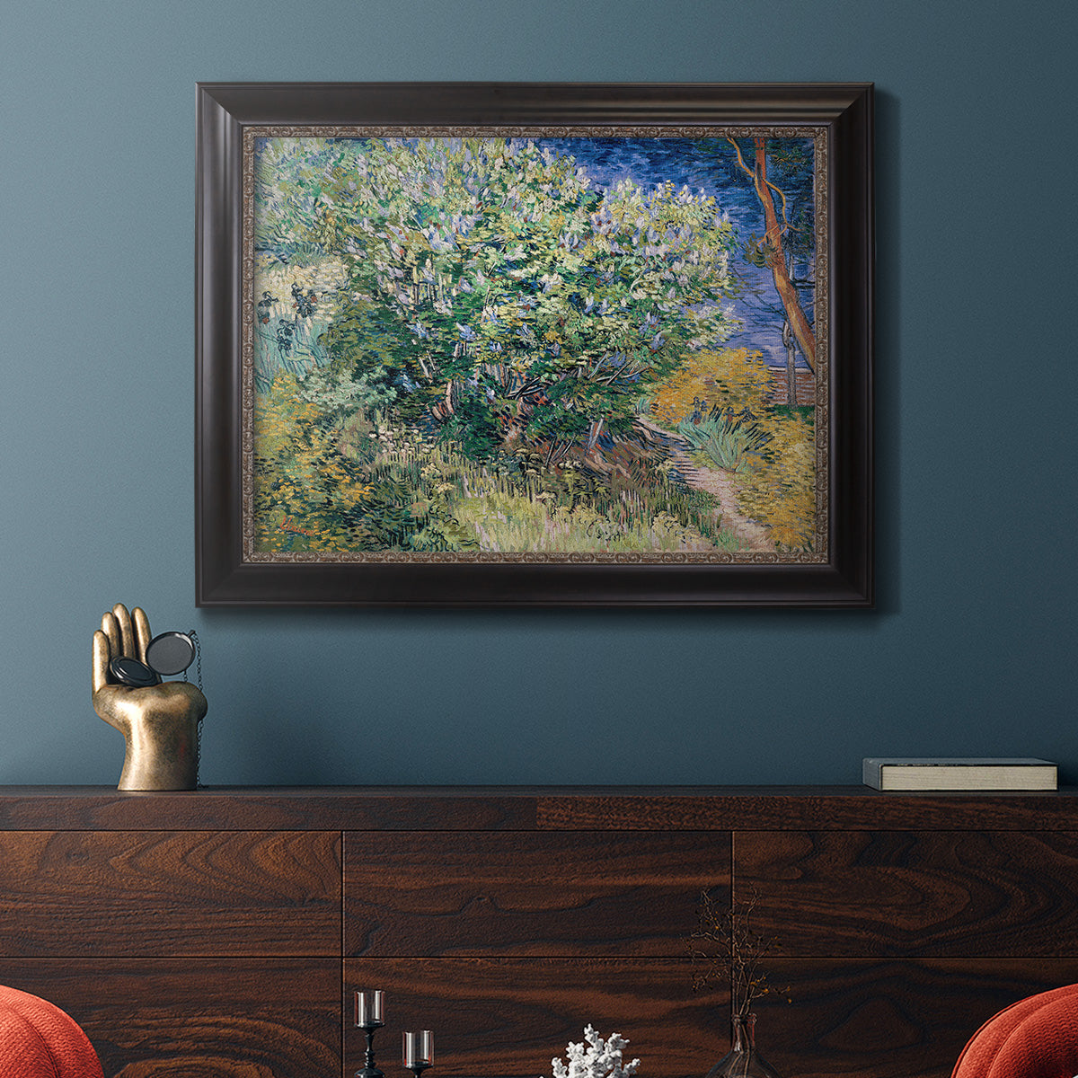 Impressionist lilac flower painting by Vincent van Gogh in an ornate black frame with gilded inner detail displayed in a dark-toned interior setting.