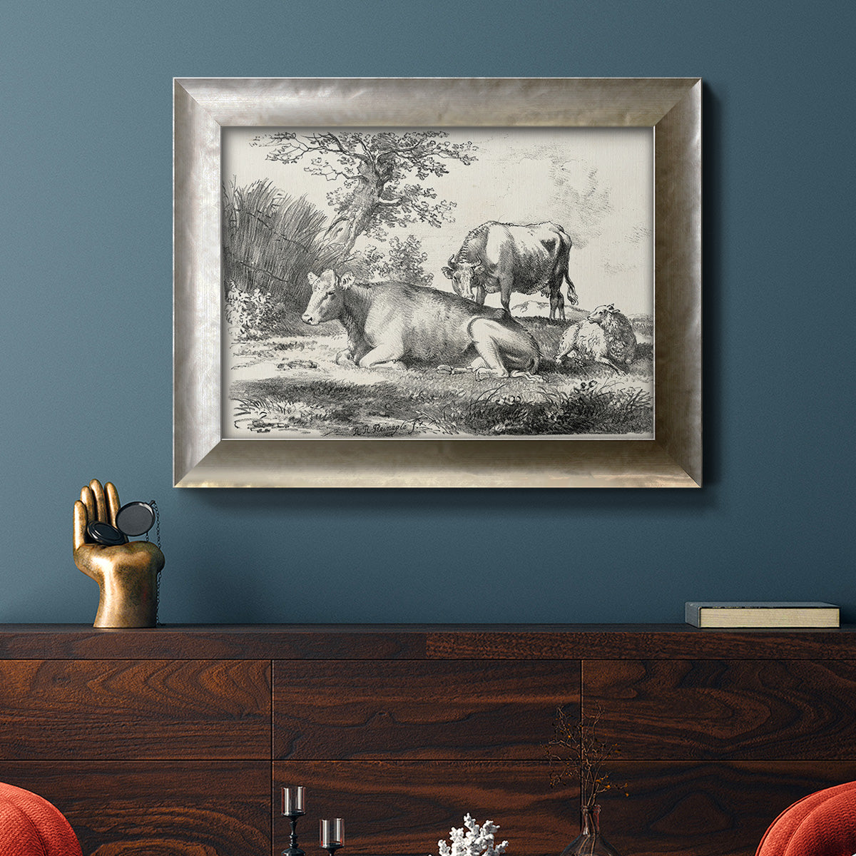 Classical pastoral landscape artwork by Nicolas Berchem in an ornate mottled silver frame displayed in a dark-toned interior setting.