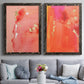 Set of two black barnwood framed canvas prints depicting paired glamorous fluid abstracts with translucent warm washes, drips, and scattered metallic accents above a sofa in a contemporary living room.