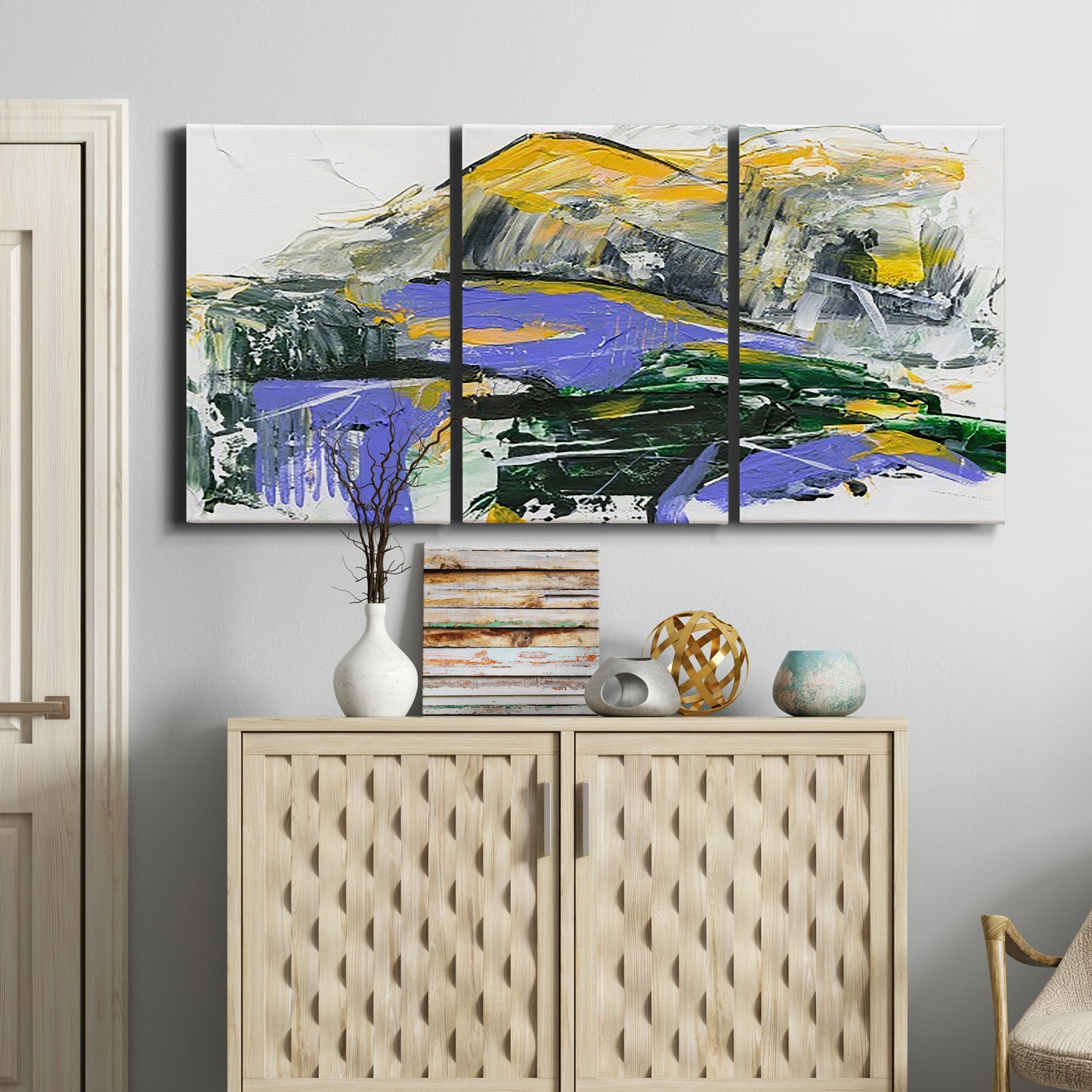 Three-panel canvas wall art featuring quiet abstract mountain silhouette, displayed above a cabinet in an entryway.