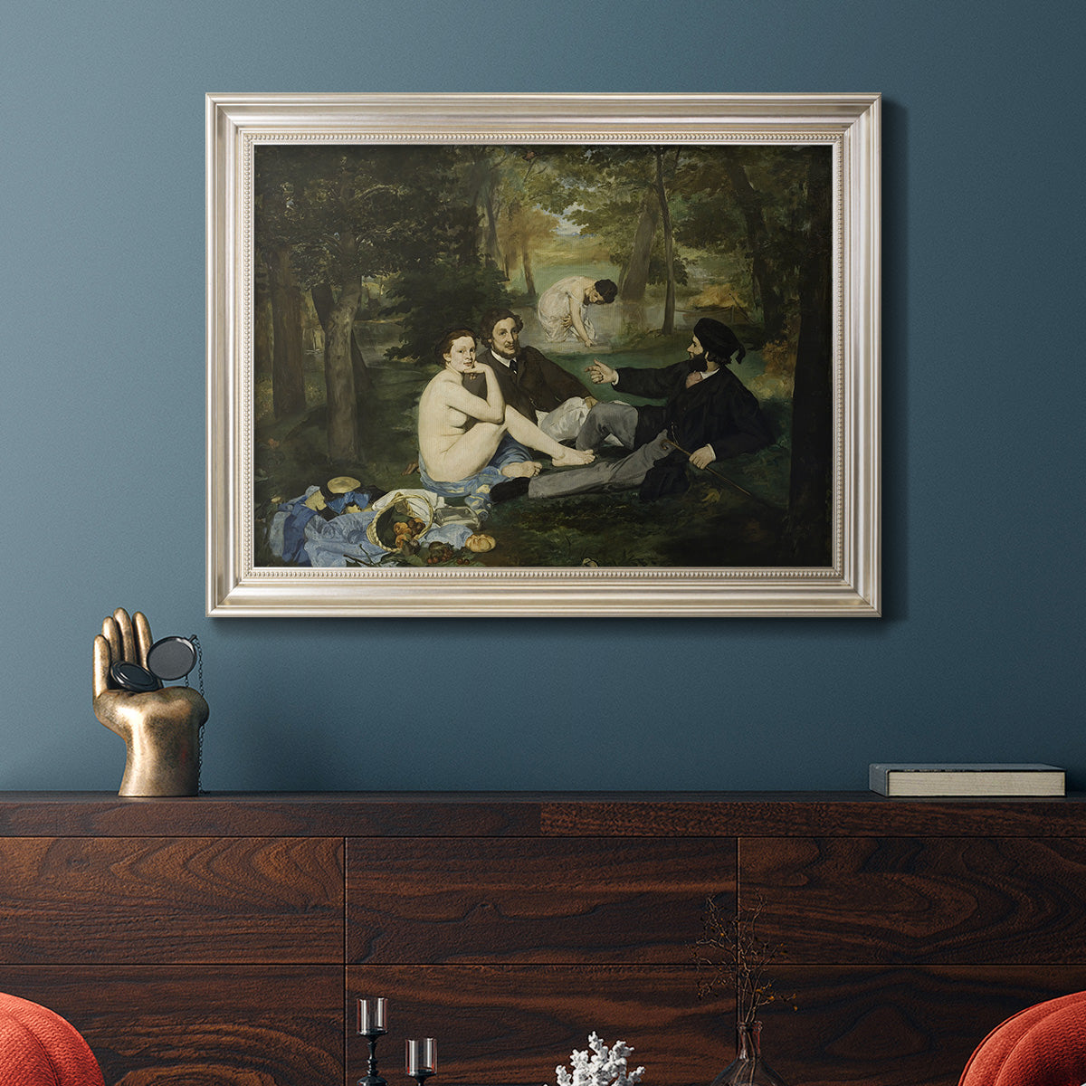 Groundbreaking impressionist picnic scene by Édouard Manet in an ornate champagne frame displayed in a dark-toned interior setting.