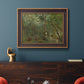 Traditional rural landscape scene with figures by Jean-Baptiste-Camille Corot in an ornate bronzed mahogany wood frame displayed in a dark-toned interior setting.