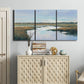 Three-panel canvas wall art featuring coastal plain meeting open water, displayed above a cabinet in an entryway.
