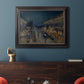 Impressionist nighttime Paris street scene by Camille Pissarro in an ornate black frame with gilded inner detail displayed in a dark-toned interior setting.