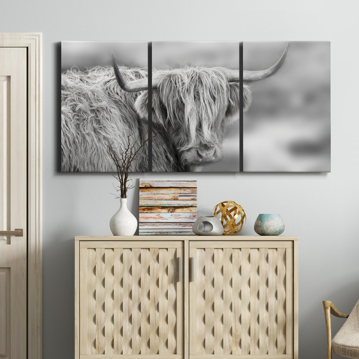 Three-panel canvas wall art featuring large highland cow portrait, displayed above a cabinet in an entryway.