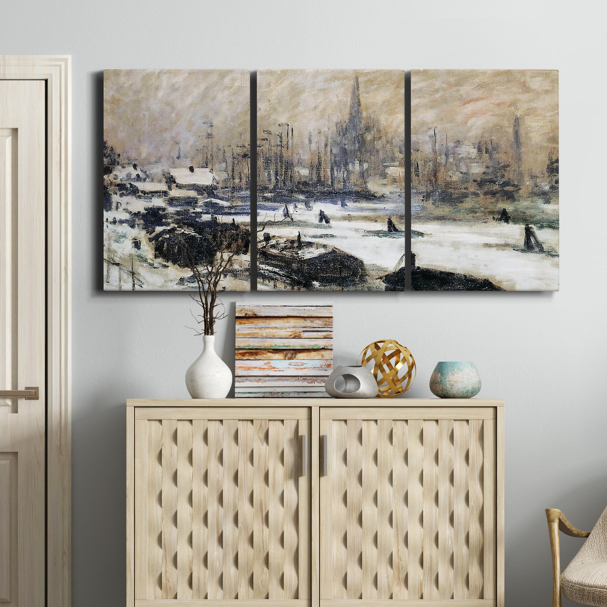 Three-panel canvas wall art featuring snowy village road in winter, displayed above a cabinet in an entryway.